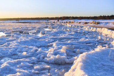 Güneş doğarken Mikoszewo 'daki Baltık Denizi sahilinde buzdan torolar. Polonya