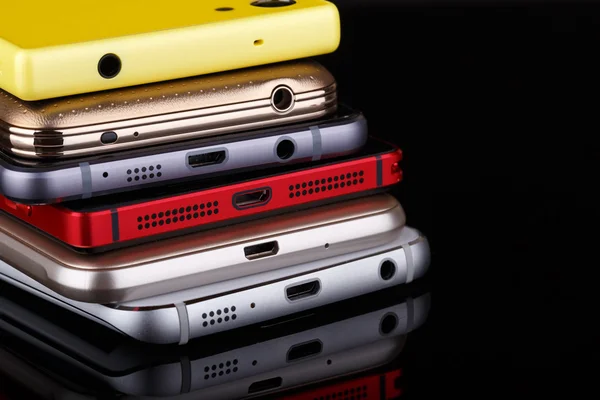 Купка електронних пристроїв крупним планом - смартфони на чорному фоні — стокове фото