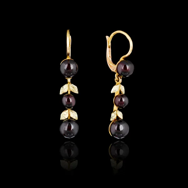 Boucles d'oreilles en or isolé sur fond noir — Photo