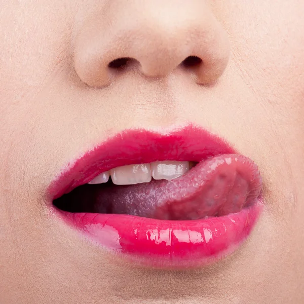 Recortado primer plano de una mujer con lápiz labial rojo y lamiéndose el labio — Foto de Stock