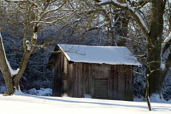 Paesaggio con capanna in legno nella neve — Foto Stock