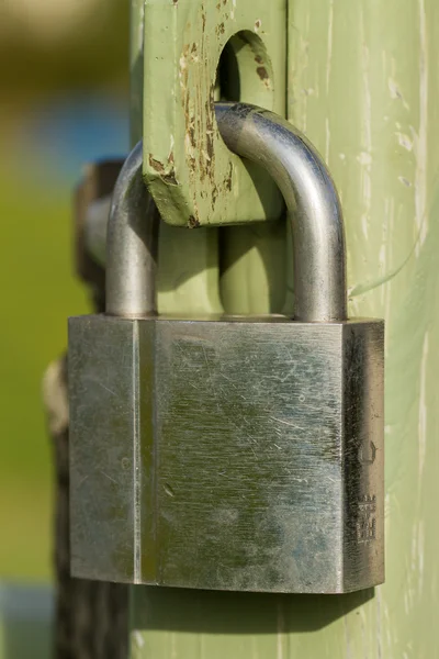 Candado de plata cerrado en una puerta de metal —  Fotos de Stock