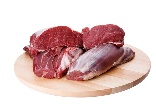 Carne crua de bovino e tábua de corte isolada sobre fundo branco — Fotografia de Stock