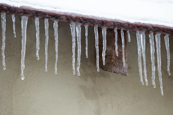 Eiszapfen, die von einem Dach herabhängen — Stockfoto