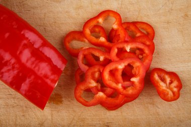 Ahşap kesme tahtası üzerinde dilimlenmiş kırmızı biber