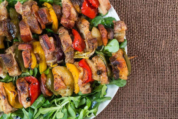 Gegrillte Fleischspieße auf einem Teller mit Gemüse — Stockfoto