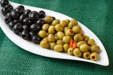 Beyaz bir plaka üzerinde yeşil ve Siyah Zeytin