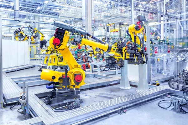 Robotok egy autógyárban Stock Kép