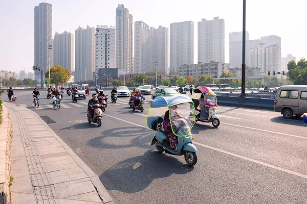 Ludzie na rowerze elektrycznym z kolorową szybą na skrzyżowaniu, Hefei, Chiny. — Zdjęcie stockowe