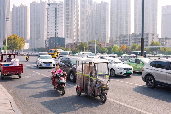 Άνθρωποι με ηλεκτρικό ποδήλατο με πολύχρωμο παρμπρίζ σε σταυροδρόμι, Hefei, Κίνα. — Φωτογραφία Αρχείου