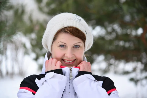Žena v sportovní bundu a čepici na zimu borový les — Stock fotografie
