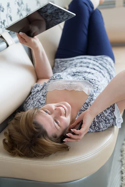 Mulher falando ao telefone deitado no sofá no quarto — Fotografia de Stock