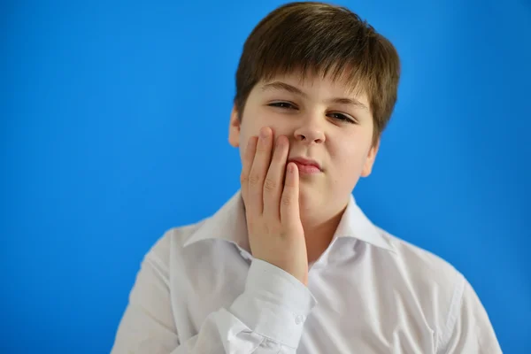 Nastoletni chłopiec z bólu zęba na jasnym tle — Zdjęcie stockowe
