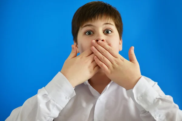 Überraschter Junge schließt Mund mit Händen — Stockfoto