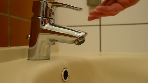 La mano femenina abre el grifo y prueba la temperatura del agua — Vídeos de Stock