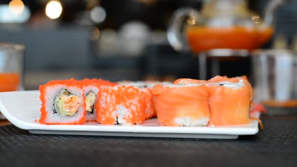 Womans hand with chopsticks take rolls — Stock Video