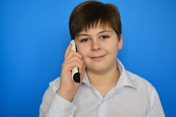 Dospívající chlapec mluví radiotelefonicky na modrém pozadí — Stock fotografie