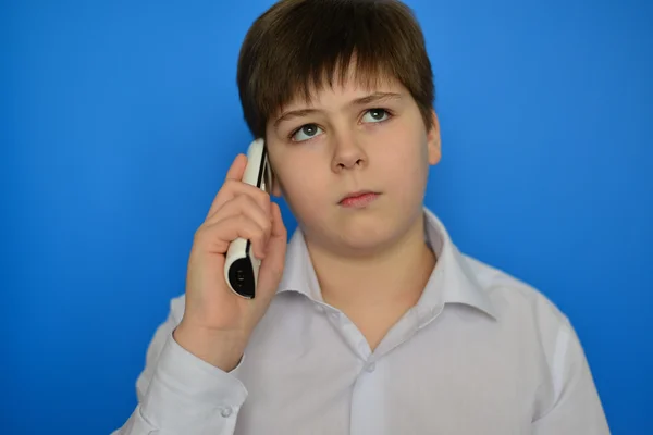 Adolescente chico hablando por radiotelefonía sobre un fondo azul — Foto de Stock