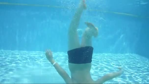 Adolescent flotte sous l'eau dans la piscine — Video
