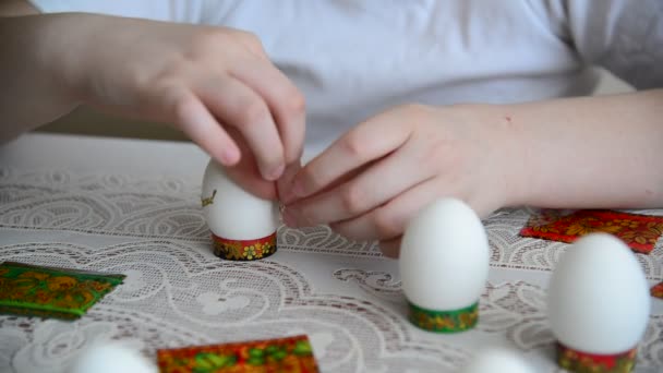 Хлопчик наклеює на великодні яйця — стокове відео