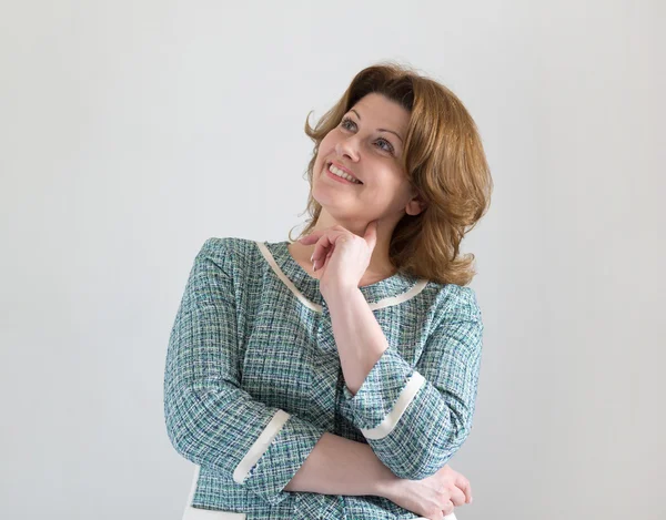 Mujer positiva en chaqueta verde mirando hacia arriba — Foto de Stock