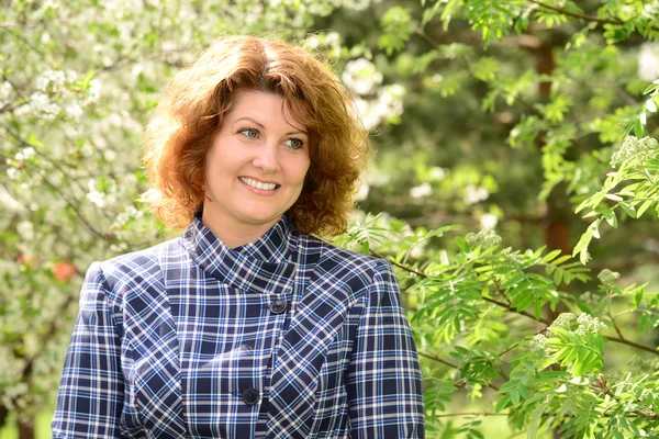 Positive smiling middle-aged woman in park — Stock Photo, Image