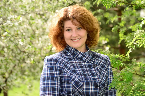 Femme d'âge moyen souriante positive dans le parc — Photo