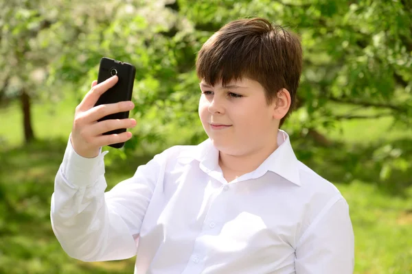 Teen chłopiec rozmowy na telefon na zewnątrz — Zdjęcie stockowe