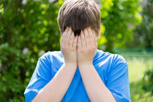 Teenie-Probleme - Junge verdeckte sein Gesicht mit seinen Händen draußen — Stockfoto