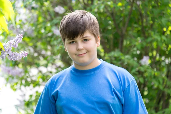 Portrait of boy in park with blooming lilacs — Stock Photo, Image