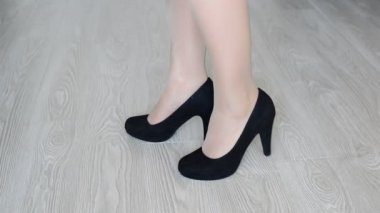 Kadın siyah yüksek topuklu ayakkabılar çıkartıyor