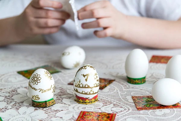 Niño palos pegatinas en los huevos de Pascua — Foto de Stock