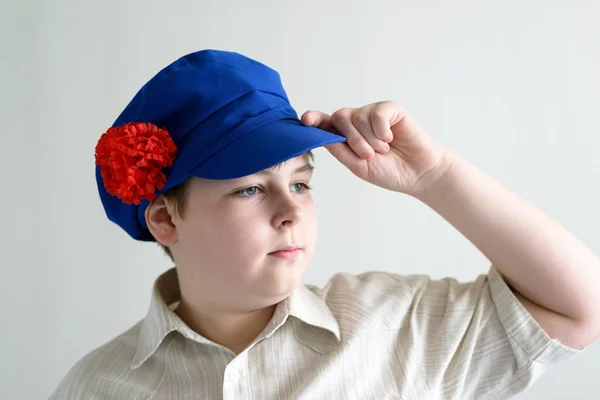 Retrato de menino adolescente em boné nacional russo com cravos — Fotografia de Stock