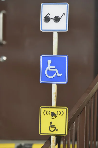 Sinais de informação para pessoas com deficiência perto da porta da frente — Fotografia de Stock