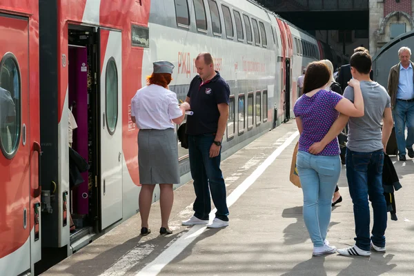 Moskva, Ryssland-juni 14,2016. CONDUCTOR kontrollerar biljetterna och dokumenten när de går ombord på tåget — Stockfoto