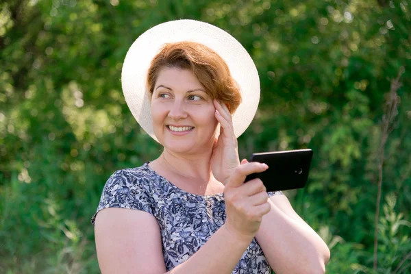 Mulher de chapéu com telefone celular fora — Fotografia de Stock