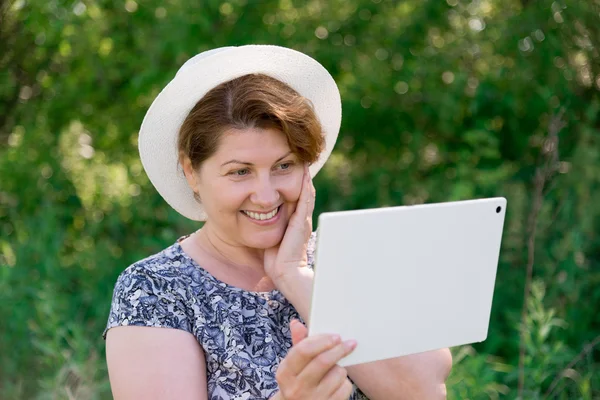 Mujer en sombrero con pc tableta exterior — Foto de Stock