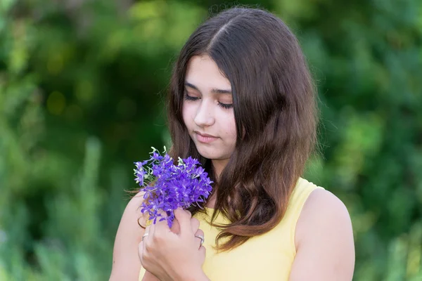 Meisje 14 jaar oud op zoek naar wilde bloemen boeket — Stockfoto