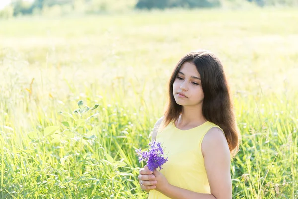 Menina com buquê de flores silvestres no campo de verão — Fotografia de Stock