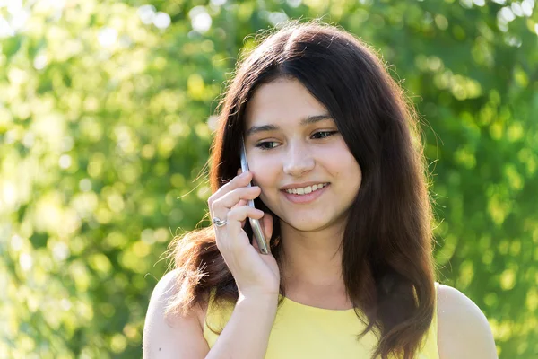 Мила дівчина розмовляє по телефону в парку — стокове фото