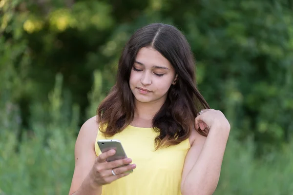 14 year girl reads sms on phone — Stock Photo, Image