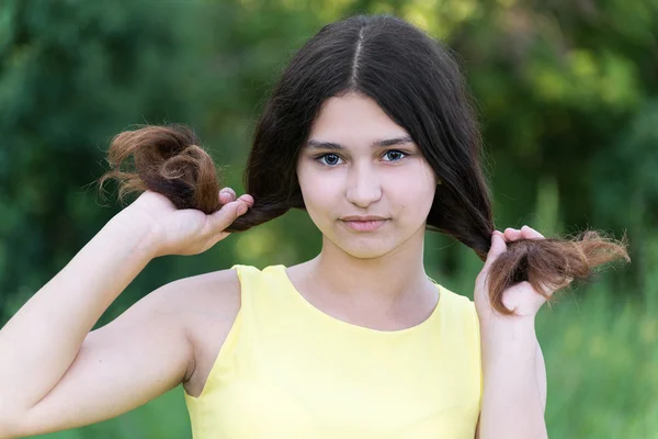 Girl holds her hands hair on nature — Stock Photo, Image