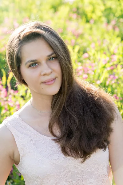 Menina em vestido rosa no prado no verão — Fotografia de Stock