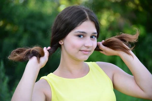 Menina segura seu cabelo nas mãos — Fotografia de Stock