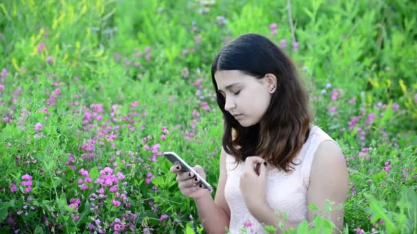 14 ano menina usa telefone ao ar livre — Vídeo de Stock