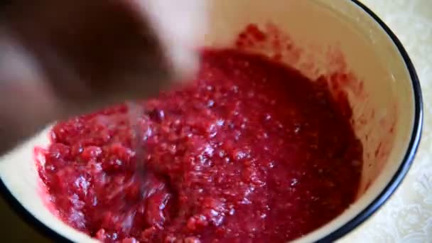 Mujer presiona frambuesa para cocinar mermelada — Vídeo de stock