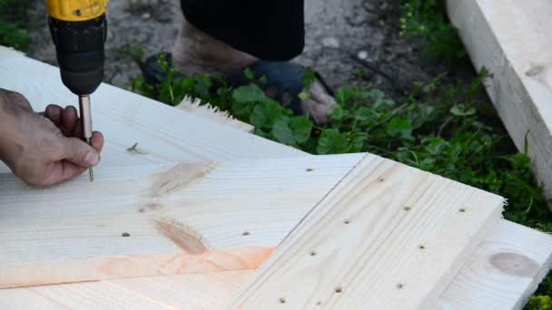 Werk lefty maakt houten hek uit houten planken — Stockvideo