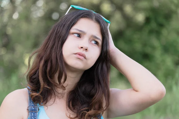 Портрет девочки-подростка, занятой проблемами в летней природе — стоковое фото