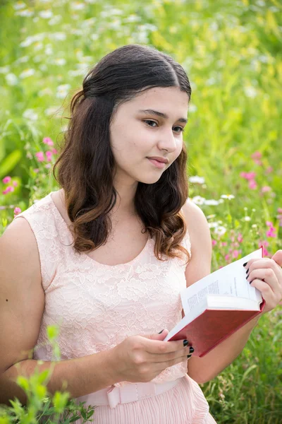 Gadis berambut gelap membaca buku tentang alam — Stok Foto