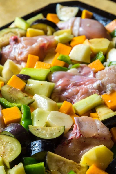 Сырая курица с овощами в кастрюле — стоковое фото